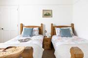 The twin bedroom is dual-aspect, with views over the countryside to the sea.