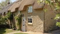 A pie crust roof graces this pretty cottage. 