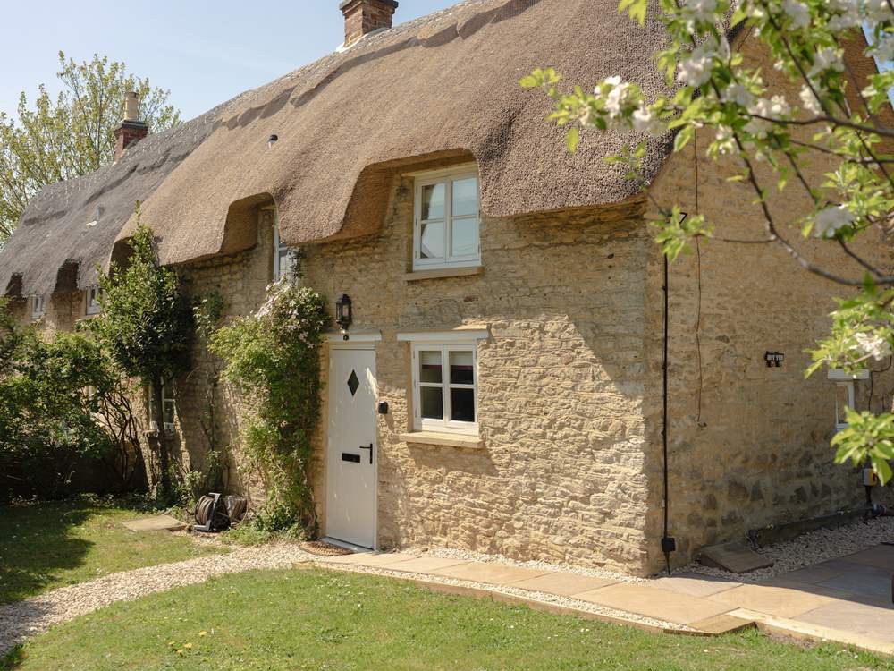 A pie crust roof graces this pretty cottage.