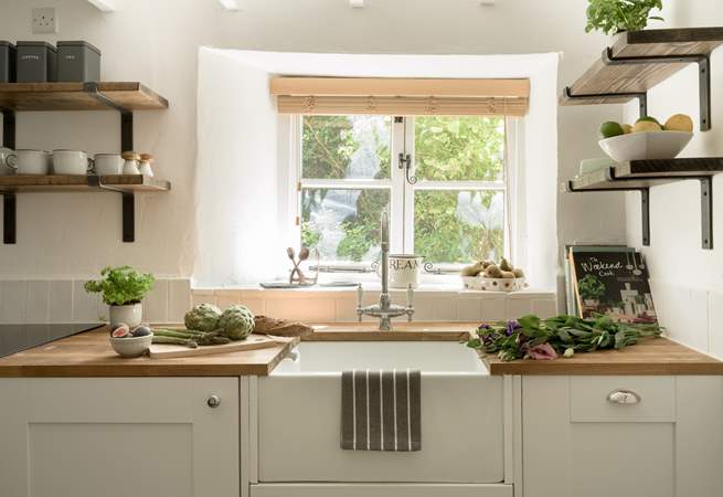 The kitchen window looks out over the front garden and the verdant hedge. 