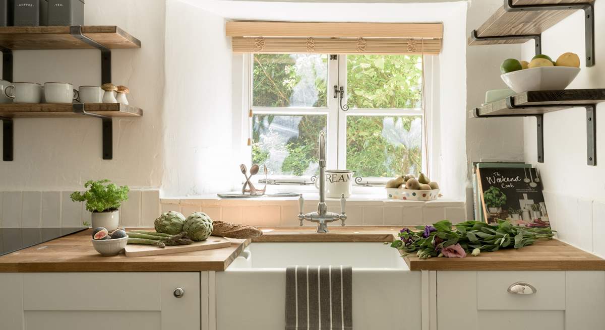 The kitchen window looks out over the front garden and the verdant hedge. 