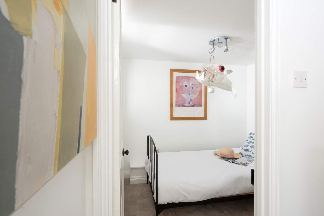 Down the stairs to the sweet single bedroom, tucked away.