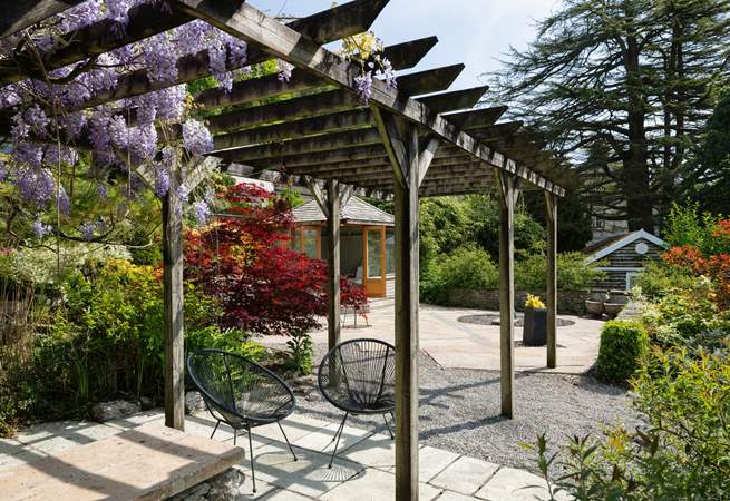 Sit in dappled shade under the pergola.