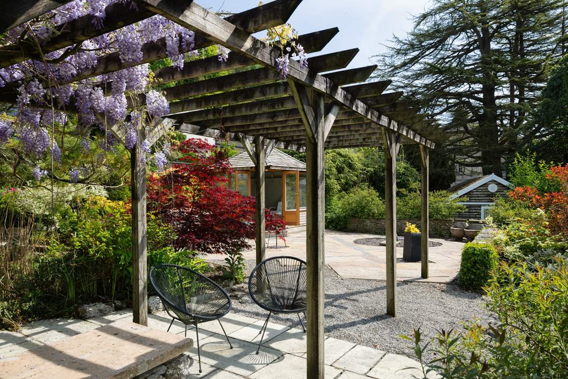 Sit in dappled shade under the pergola.
