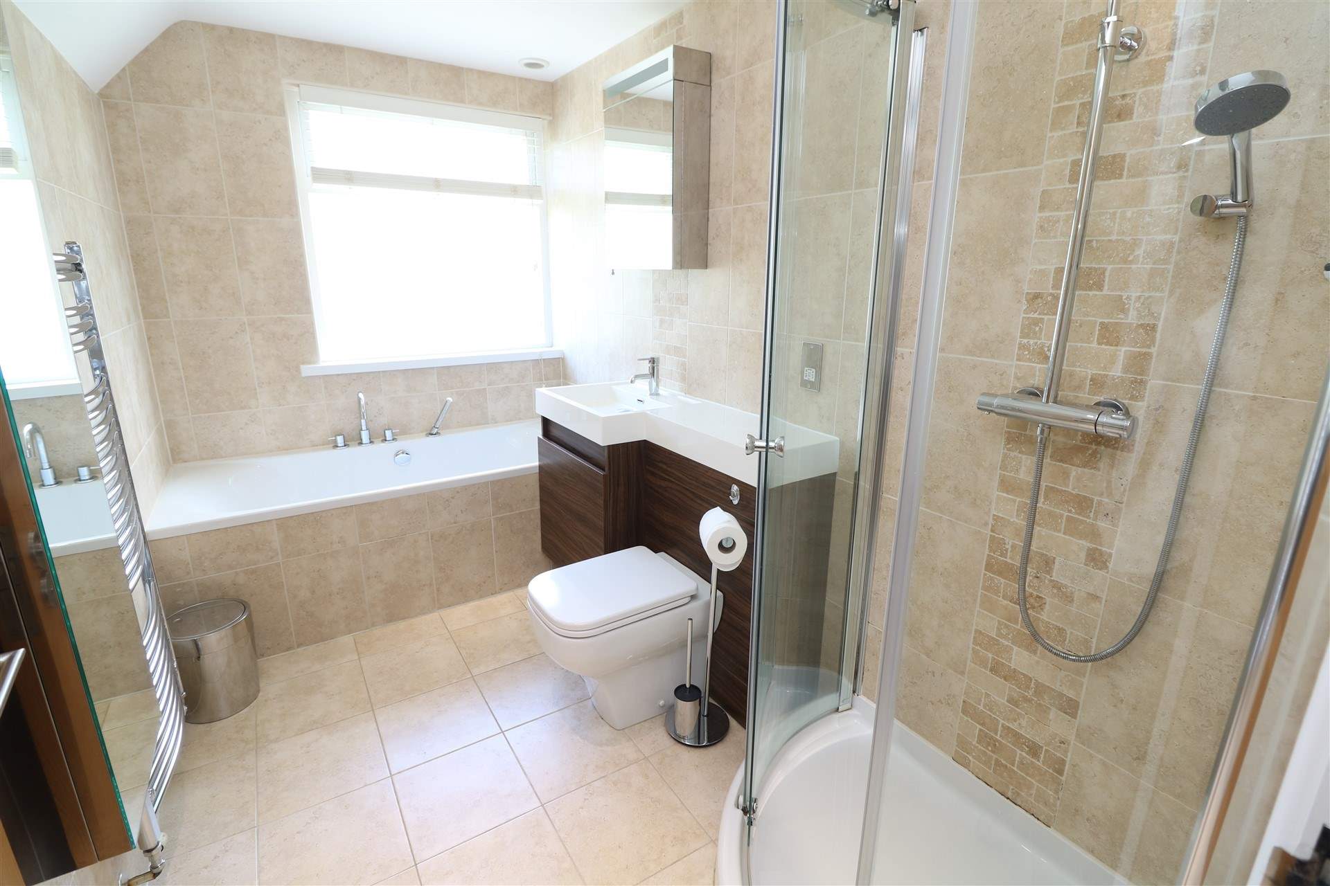 The stylish family bathroom has a bath and separate shower cubicle. 
