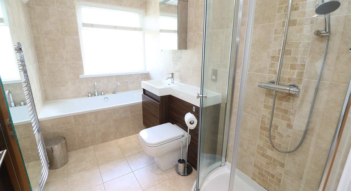 The stylish family bathroom has a bath and separate shower cubicle. 