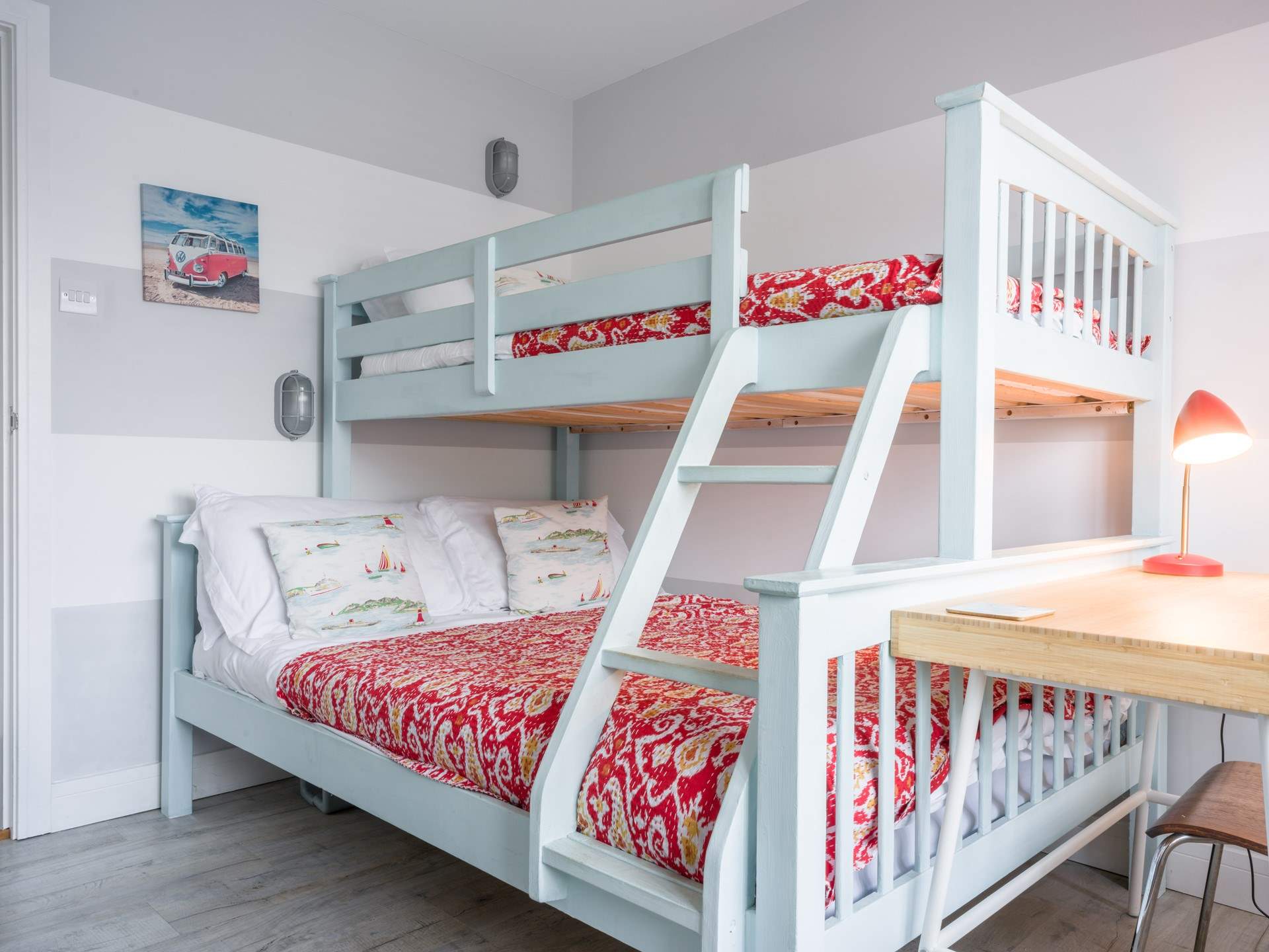 The perfect bright bunk bed room with a double bed on the bottom and a single on top.