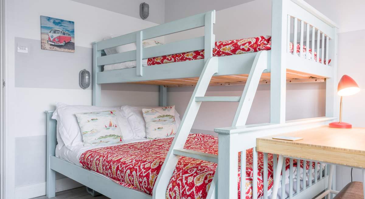 The perfect bright bunk bed room with a double bed on the bottom and a single on top.