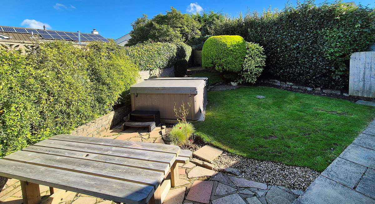 The garden area has a table for al fresco dining and a hot tub for relaxing after a busy day.