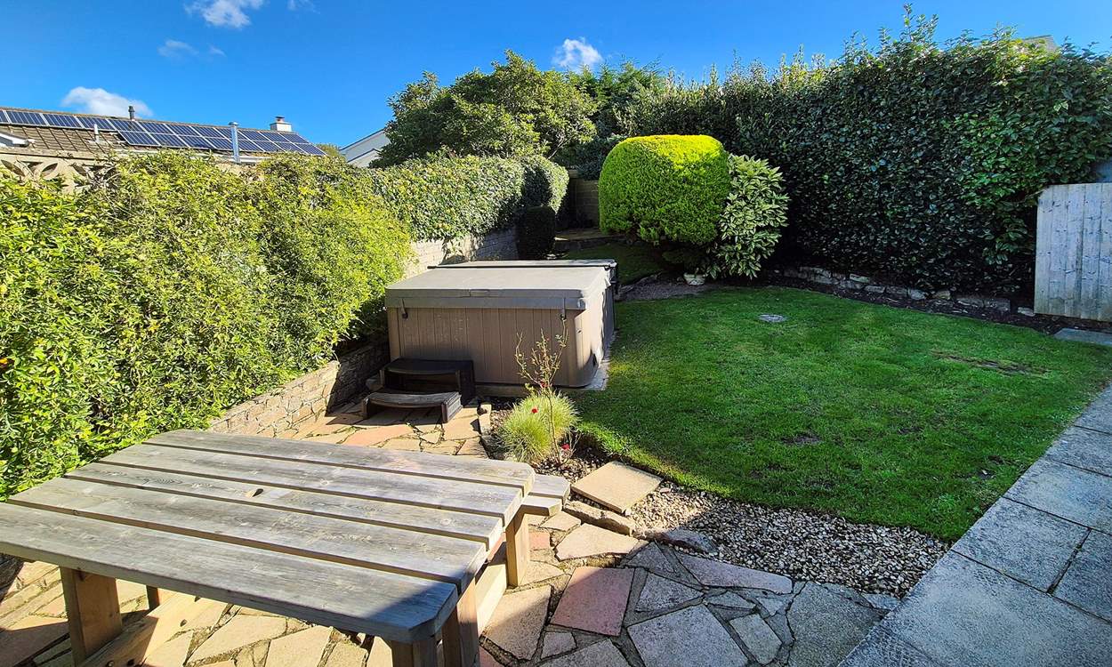 The garden area has a table for al fresco dining and a hot tub for relaxing after a busy day.