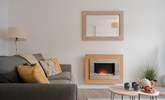 The sitting-room has a pebble-effect electric fire for cosy evenings. - Thumbnail Image