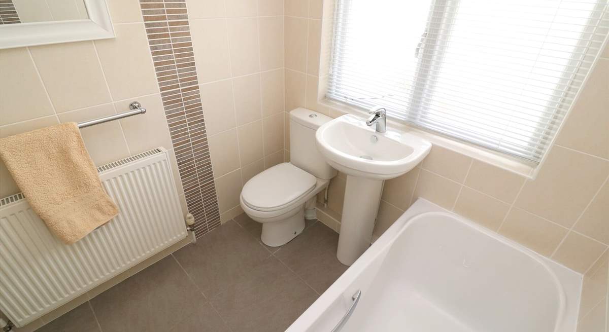 The family bathroom on the ground floor has a bath for a long soak after a busy beach day. 