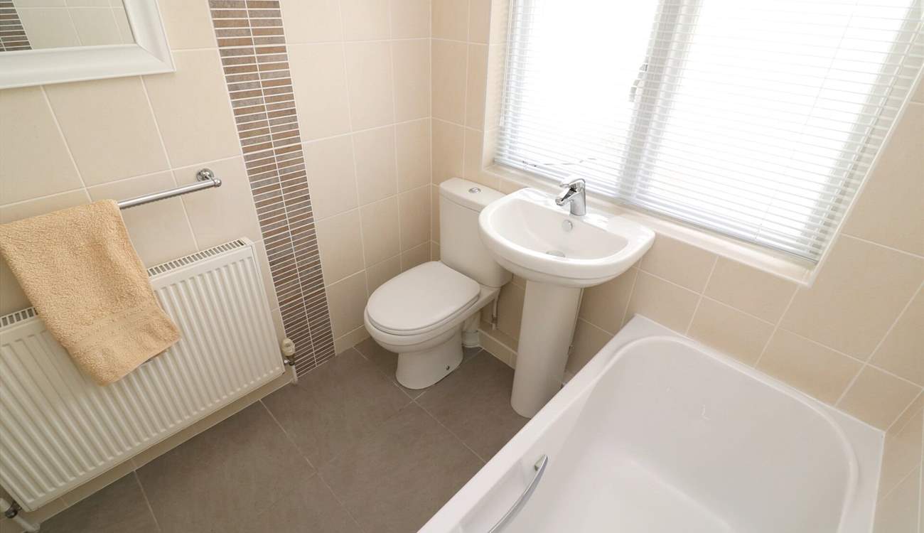 The family bathroom on the ground floor has a bath for a long soak after a busy beach day. 