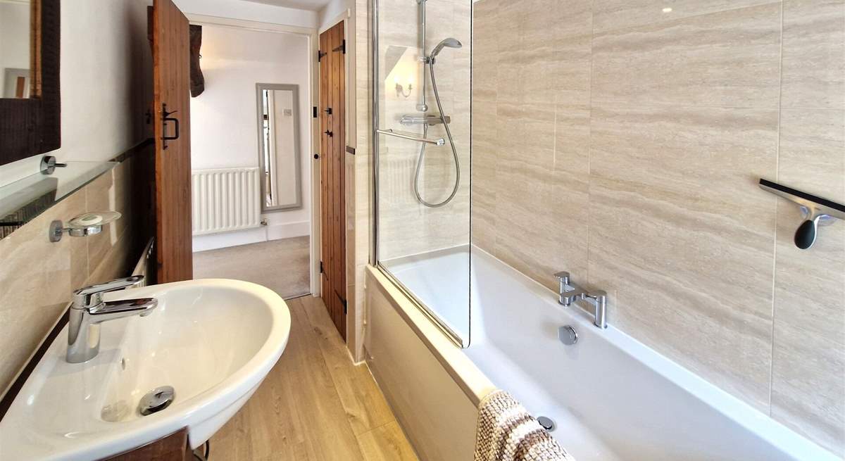 The family bathroom has a bath with shower over. 