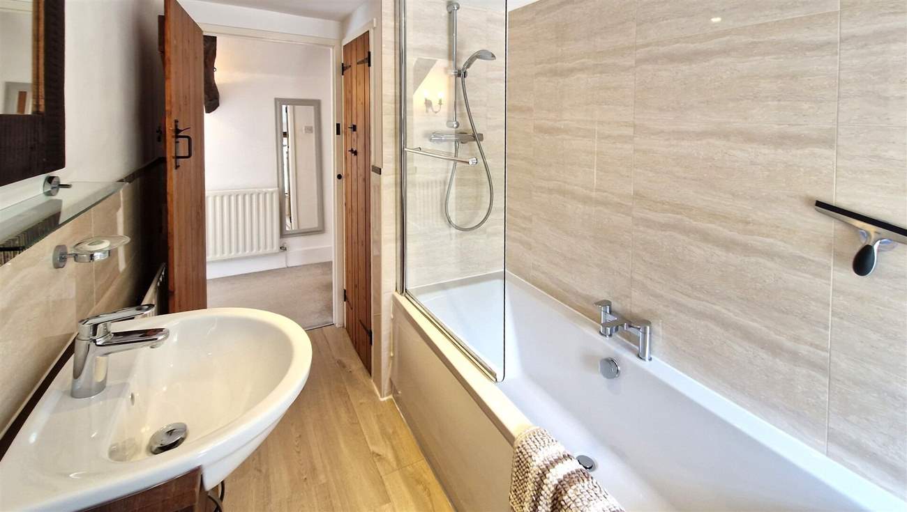 The family bathroom has a bath with shower over.