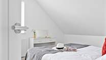 Climb the stairs to find the third bedroom with vaulted ceilings.