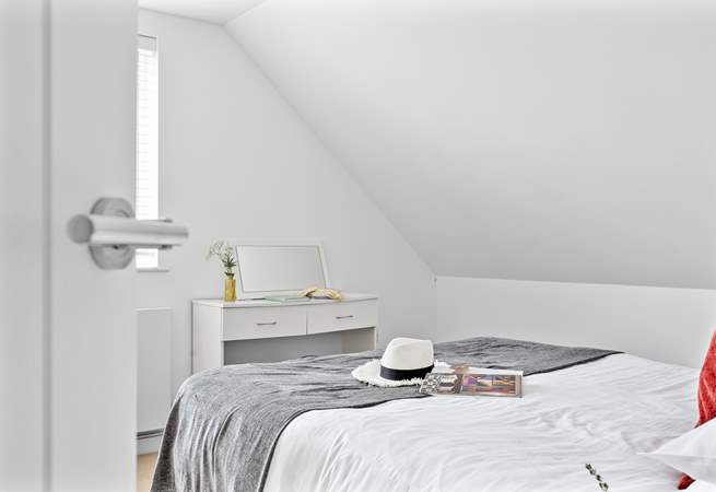 Climb the stairs to find the third bedroom with vaulted ceilings.