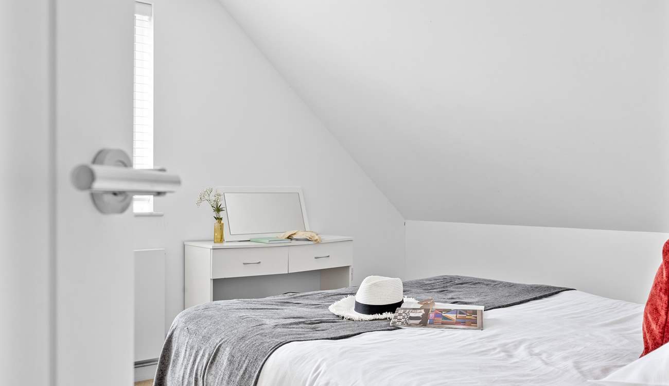 Climb the stairs to find the third bedroom with vaulted ceilings.