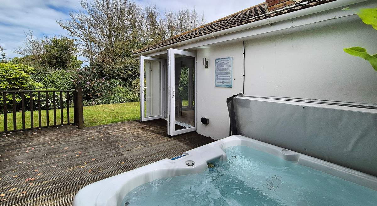 The hot tub sits on the deck area.