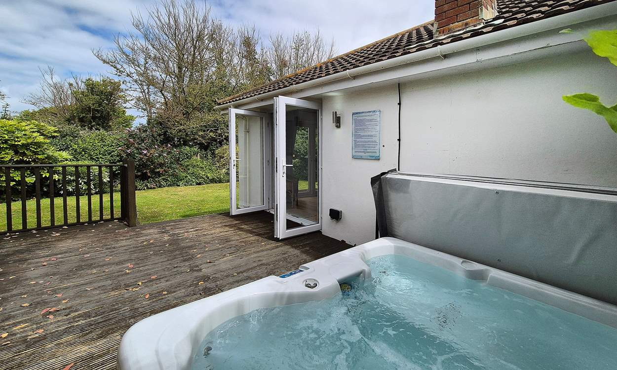 The hot tub sits on the deck area.