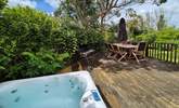 The pretty garden is home to a bubbling hot tub and outside furniture for al fresco dining.  - Thumbnail Image