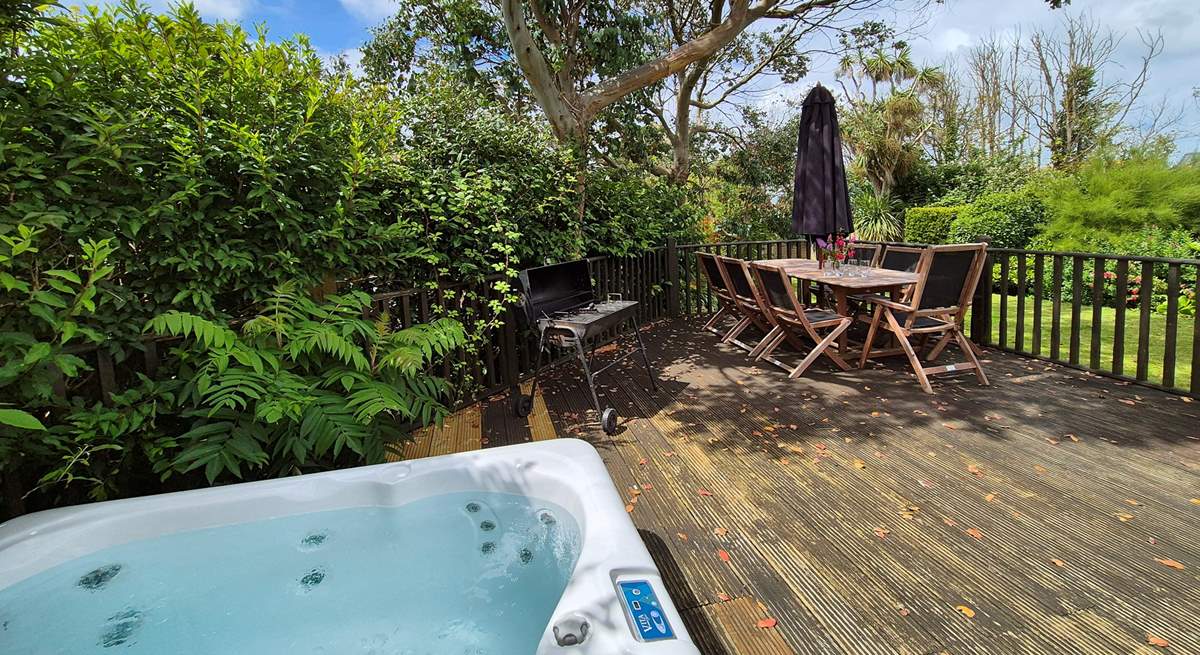 The pretty garden is home to a bubbling hot tub and outside furniture for al fresco dining. 