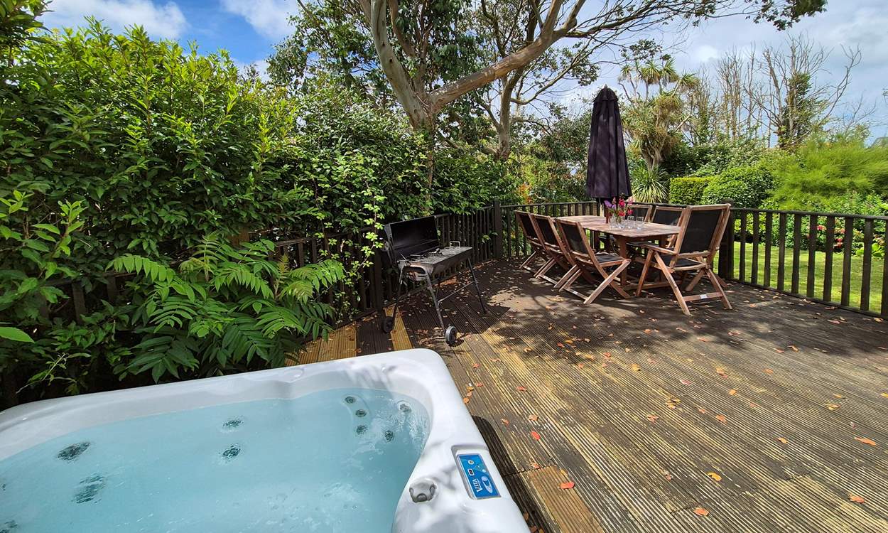 The pretty garden is home to a bubbling hot tub and outside furniture for al fresco dining.