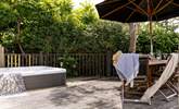 The pretty garden is home to a bubbling hot tub and outside furniture for al fresco dining.  - Thumbnail Image