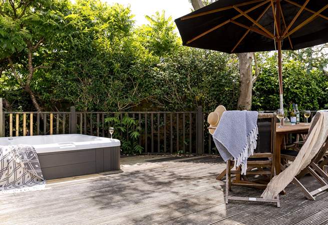 The pretty garden is home to a bubbling hot tub and outside furniture for al fresco dining. 
