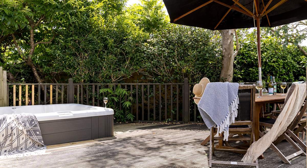 The pretty garden is home to a bubbling hot tub and outside furniture for al fresco dining. 
