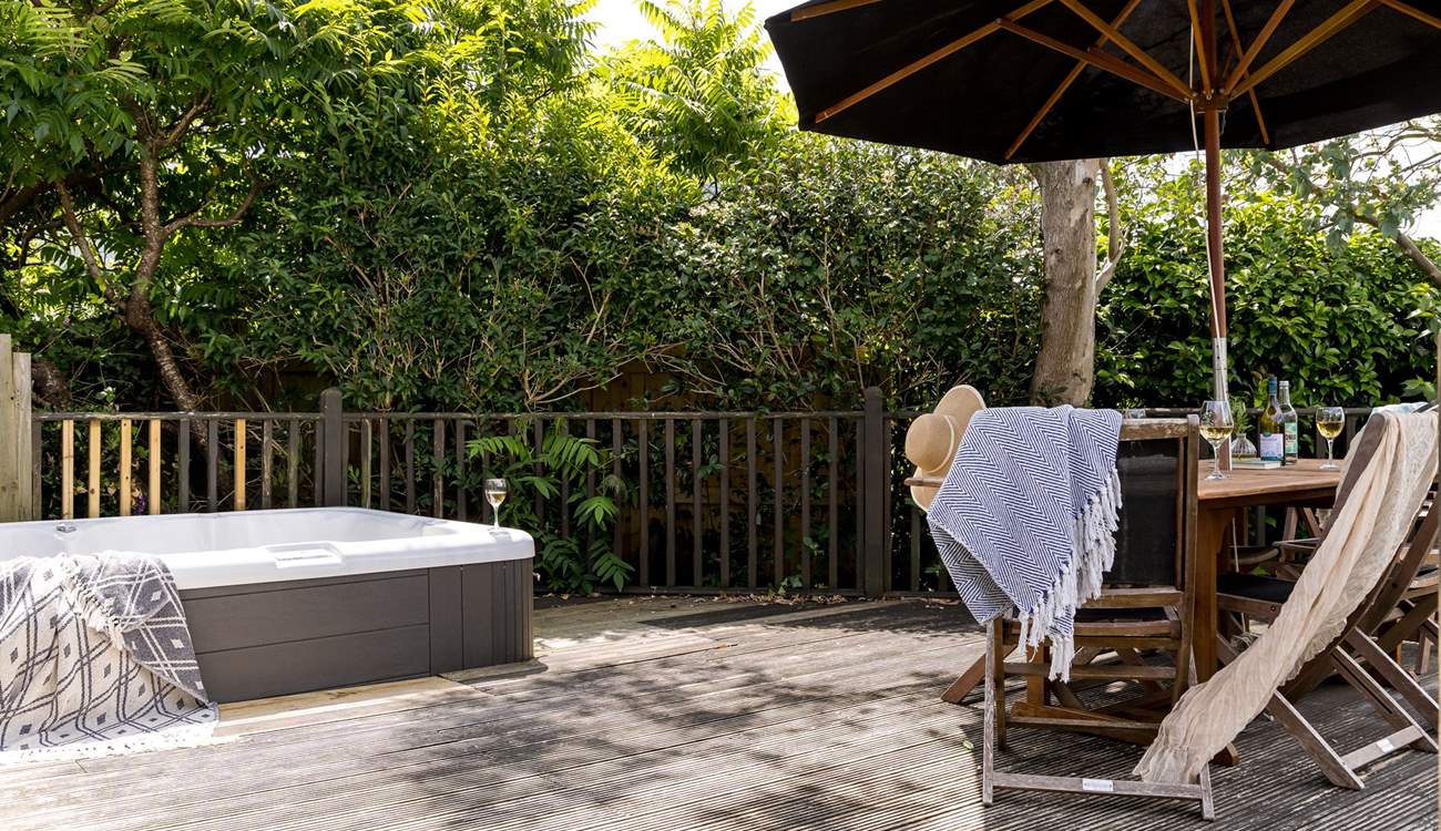 The pretty garden is home to a bubbling hot tub and outside furniture for al fresco dining. 
