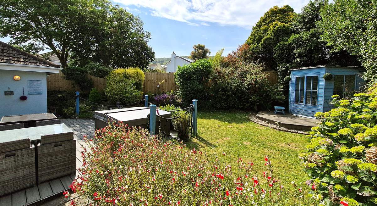 The tranquil garden is surrounded by trees and mature shrubs.