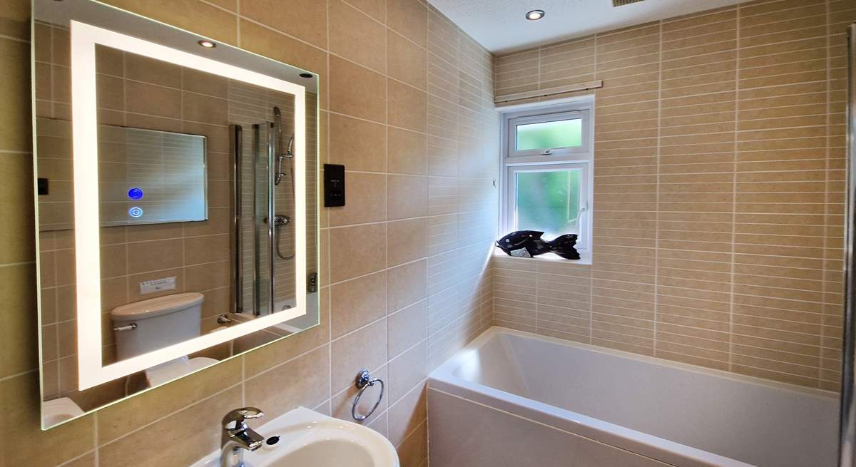 The family bathroom has a bath with shower over. 
