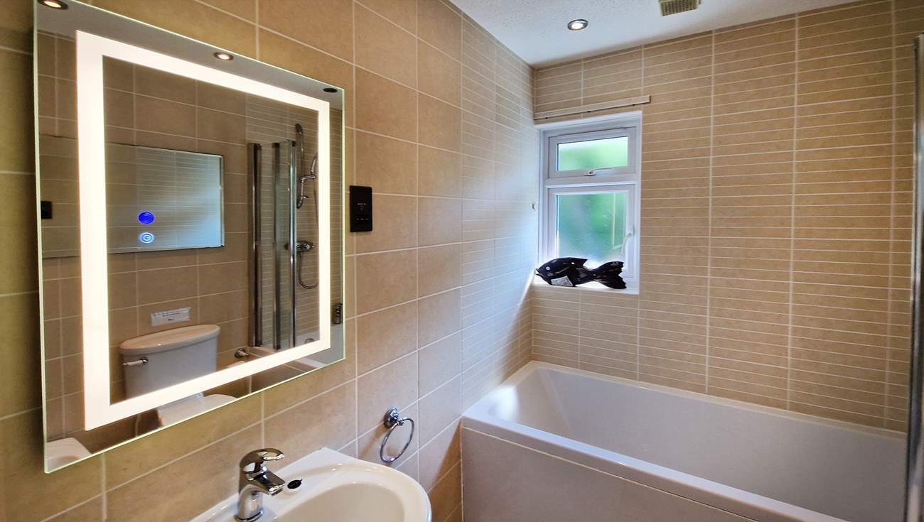 The family bathroom has a bath with shower over.