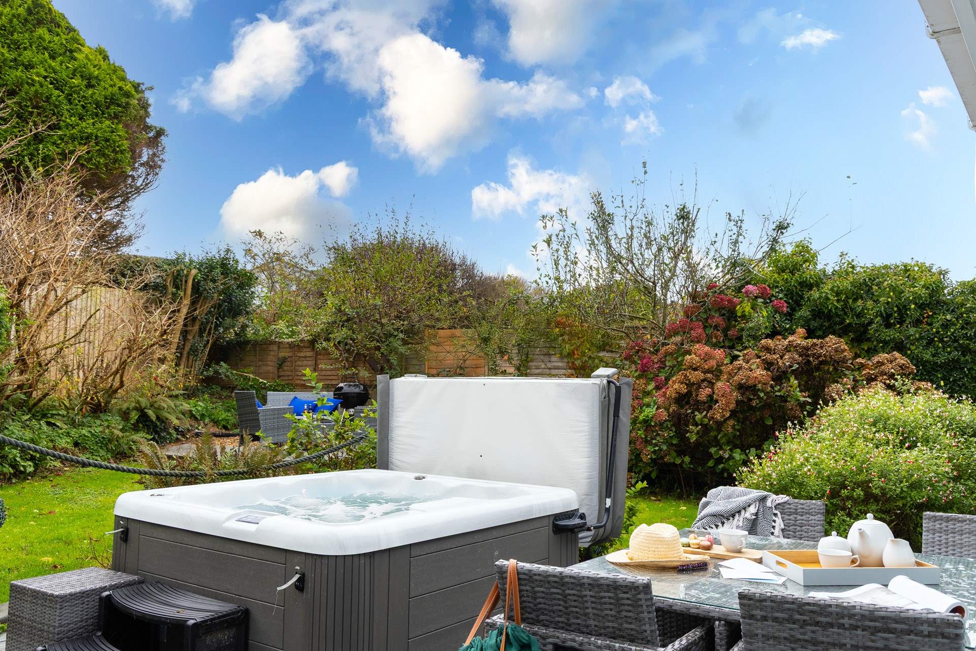 The tranquil garden is surrounded by trees and mature shrubs.