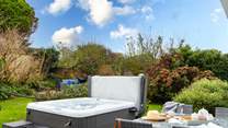 The tranquil garden is surrounded by trees and mature shrubs.