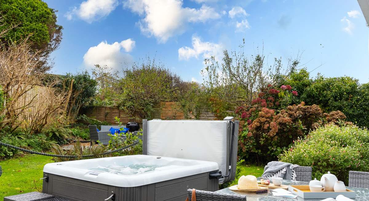 The tranquil garden is surrounded by trees and mature shrubs.