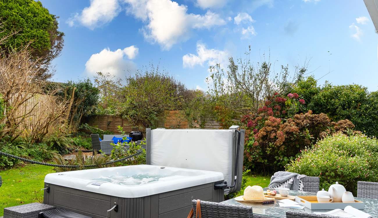 The tranquil garden is surrounded by trees and mature shrubs.