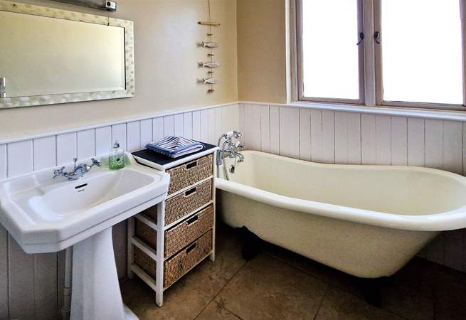 The family bathroom has a bath with hand shower attachment. 