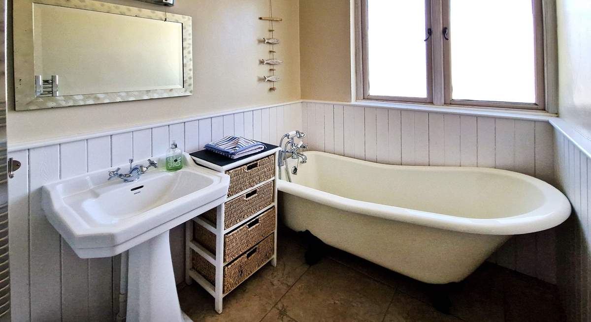 The family bathroom has a bath with hand-held shower. 