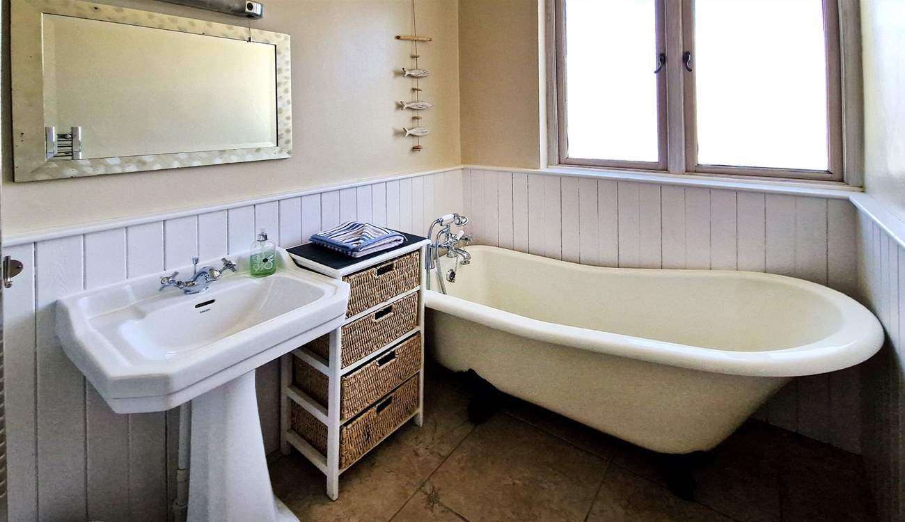 The family bathroom has a bath with hand shower attachment. 