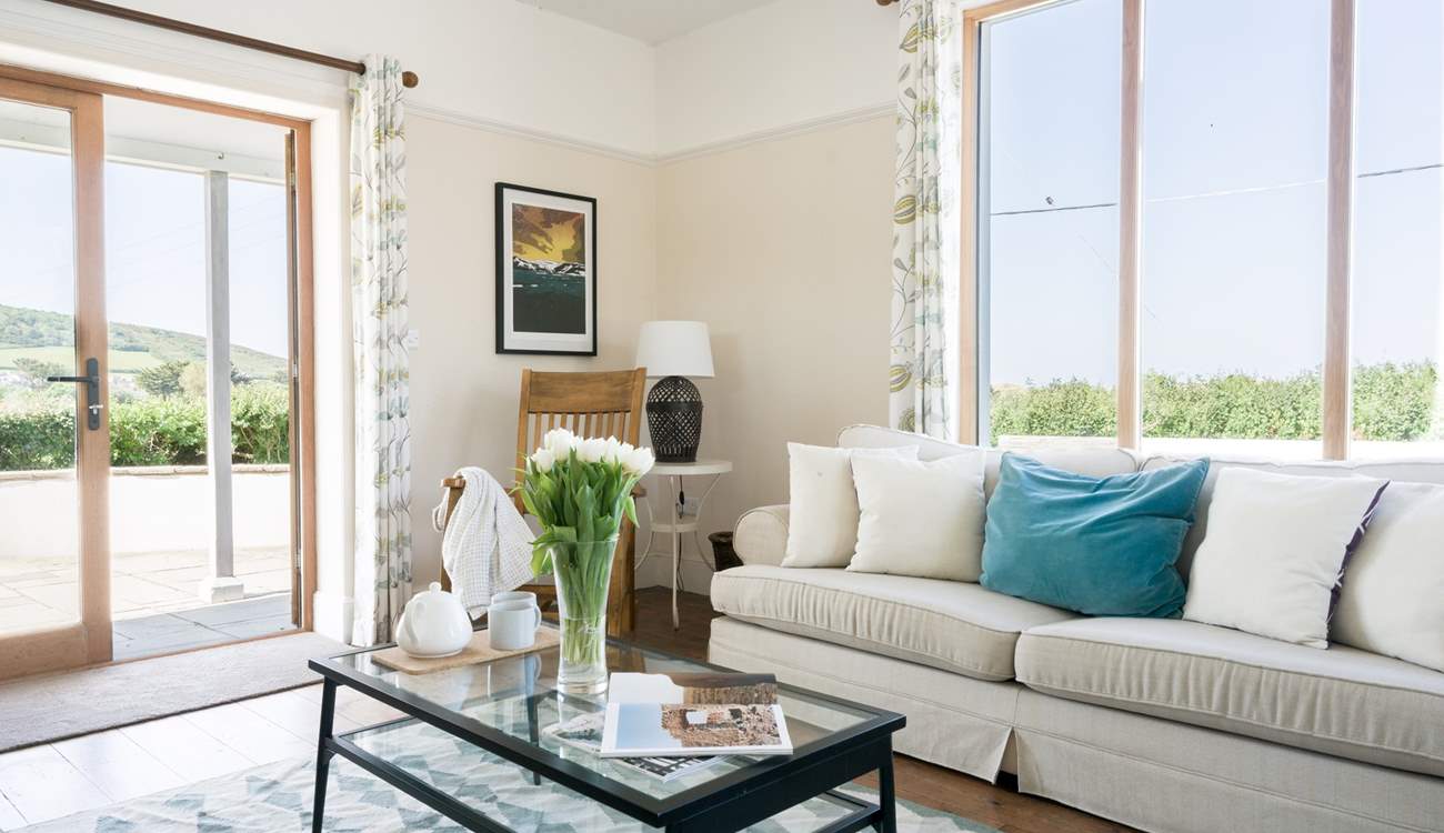 The sitting room has two sofa's a log burner and patio doors that open up on to a stunning view.