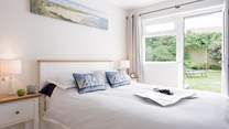 Bedroom 2 offers the perfect spot to relax and recharge with a door out to the back garden.