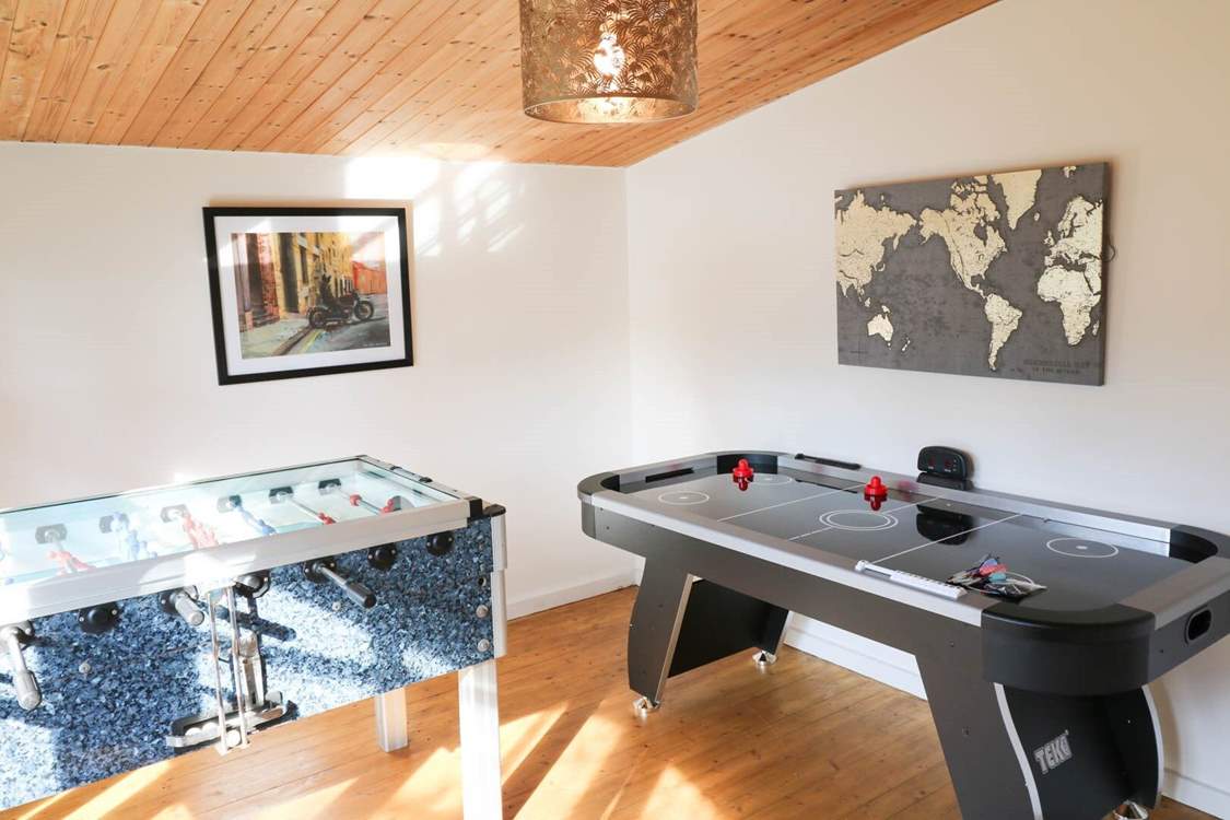 The games-room is at the bottom of the garden with an air hockey table, table football and retro arcade games machine.
