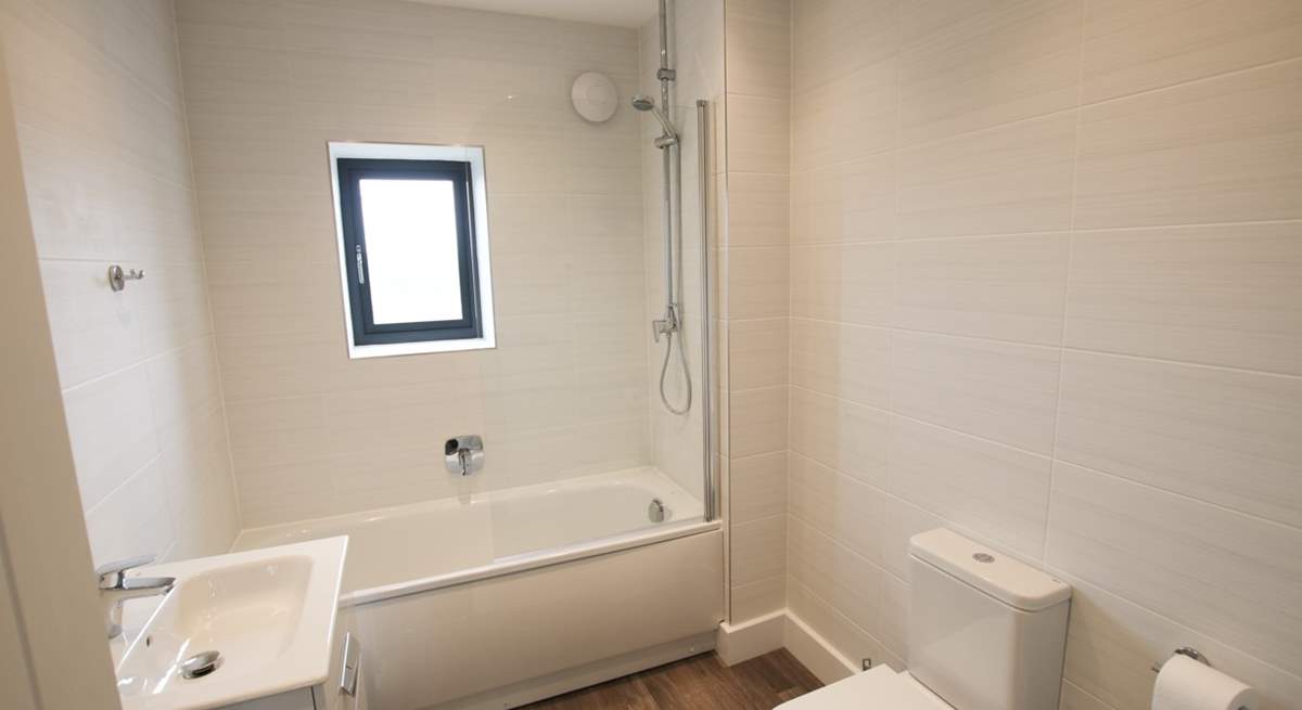 The family bathroom has a bath with shower over. 