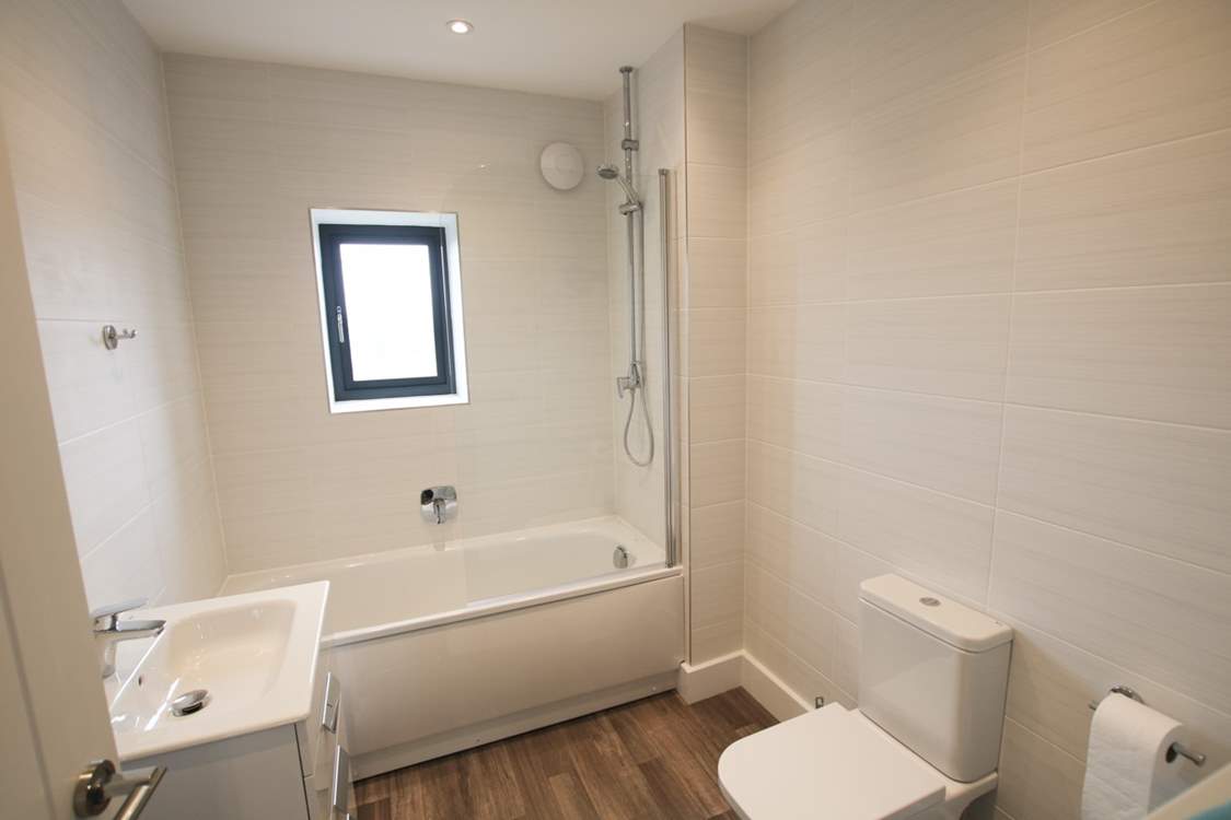 The family bathroom has a bath with shower over.
