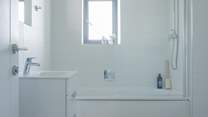 The family bathroom has a bath with shower over. 