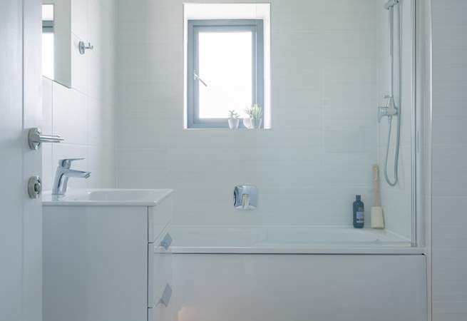 The family bathroom has a bath with shower over. 