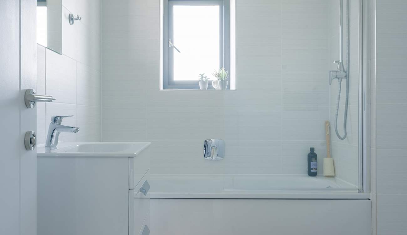 The family bathroom has a bath with shower over. 