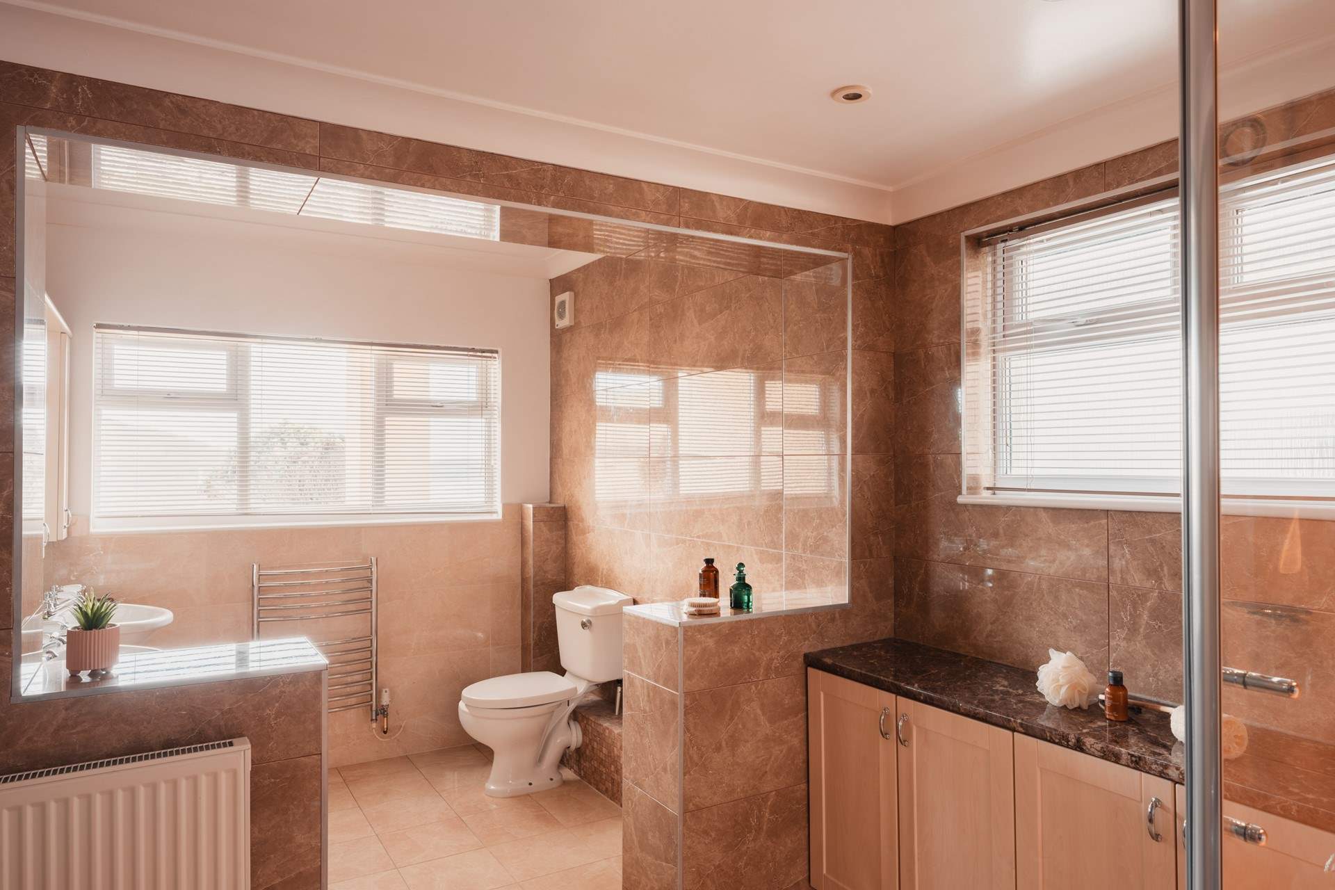 Bedroom 1's stylish en suit has a corner bath...